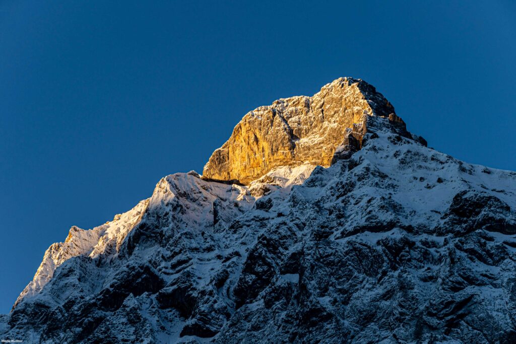 Die ersten Sonnenstrahlen über dem Gitschen im Kanton Uri verleihen dem Bild eine magische Atmosphäre und symbolisieren den Beginn eines neuen Tages voller Möglichkeiten und Abenteuer. Es ist ein Moment der Ruhe und des Erwachens, der die Schönheit der Natur und die Kraft der Sonne hervorhebt.