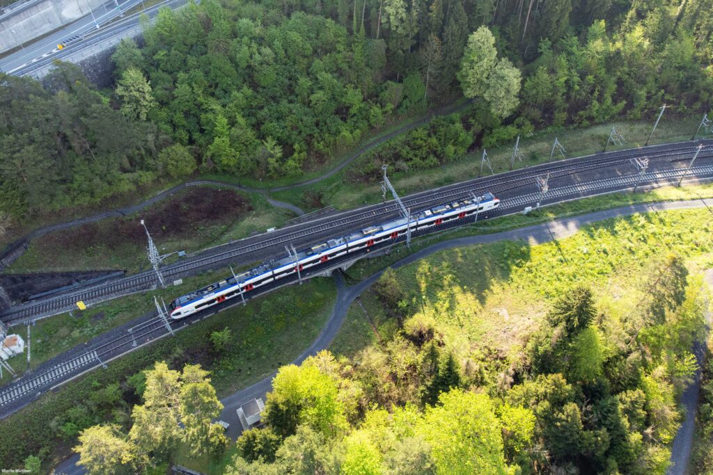 Die Drohnenfotografie fängt den Zugverkehr am Gruonbach in Flüelen, Kanton Uri, ein.