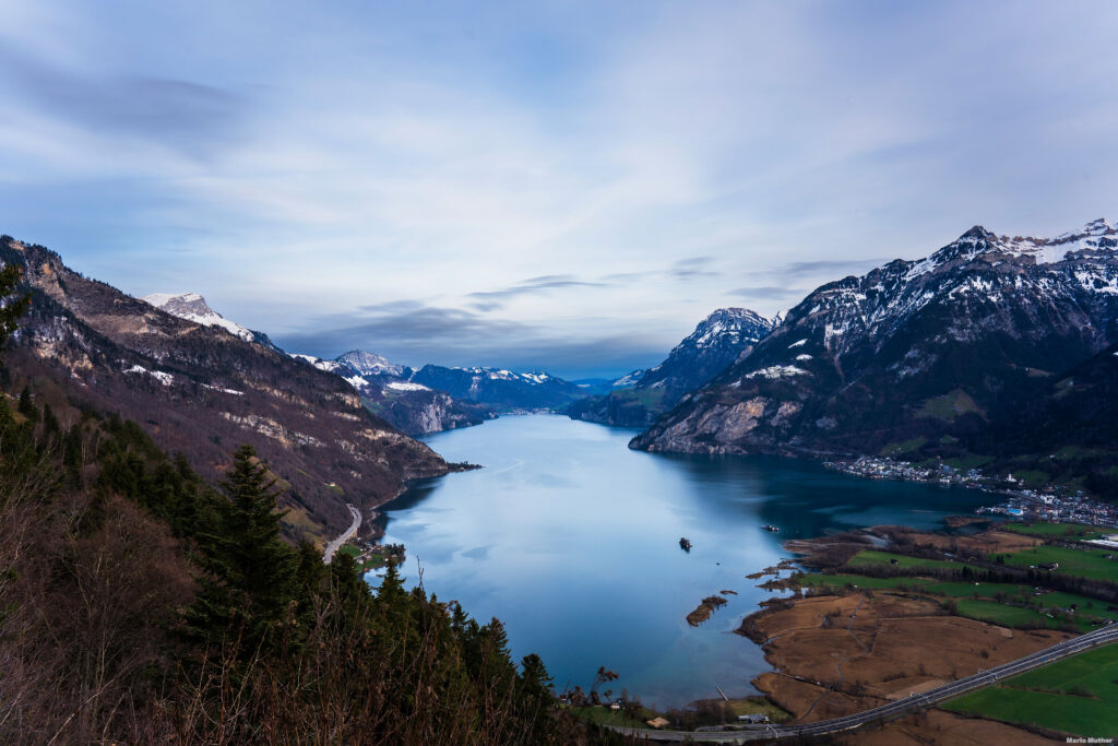 Die Drohnenfotografie zeigt den wunderschönen Urnersee im Kanton Uri. Das Bild erfasst die Weite des Sees und die umliegende Landschaft aus der Vogelperspektive. Der Urnersee ist bekannt für seine klaren, türkisfarbenen Gewässer und die majestätischen Berge, die ihn umgeben.